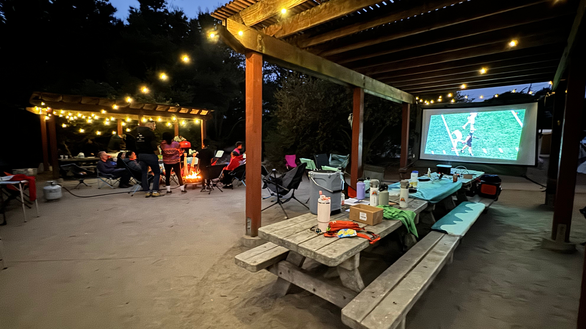 Warm LED string lights strung between trees at a forest campsite during twilight, creating a cozy ambient glow Warm LED string lights strung between trees at a forest campsite during twilight, creating a cozy ambient glow