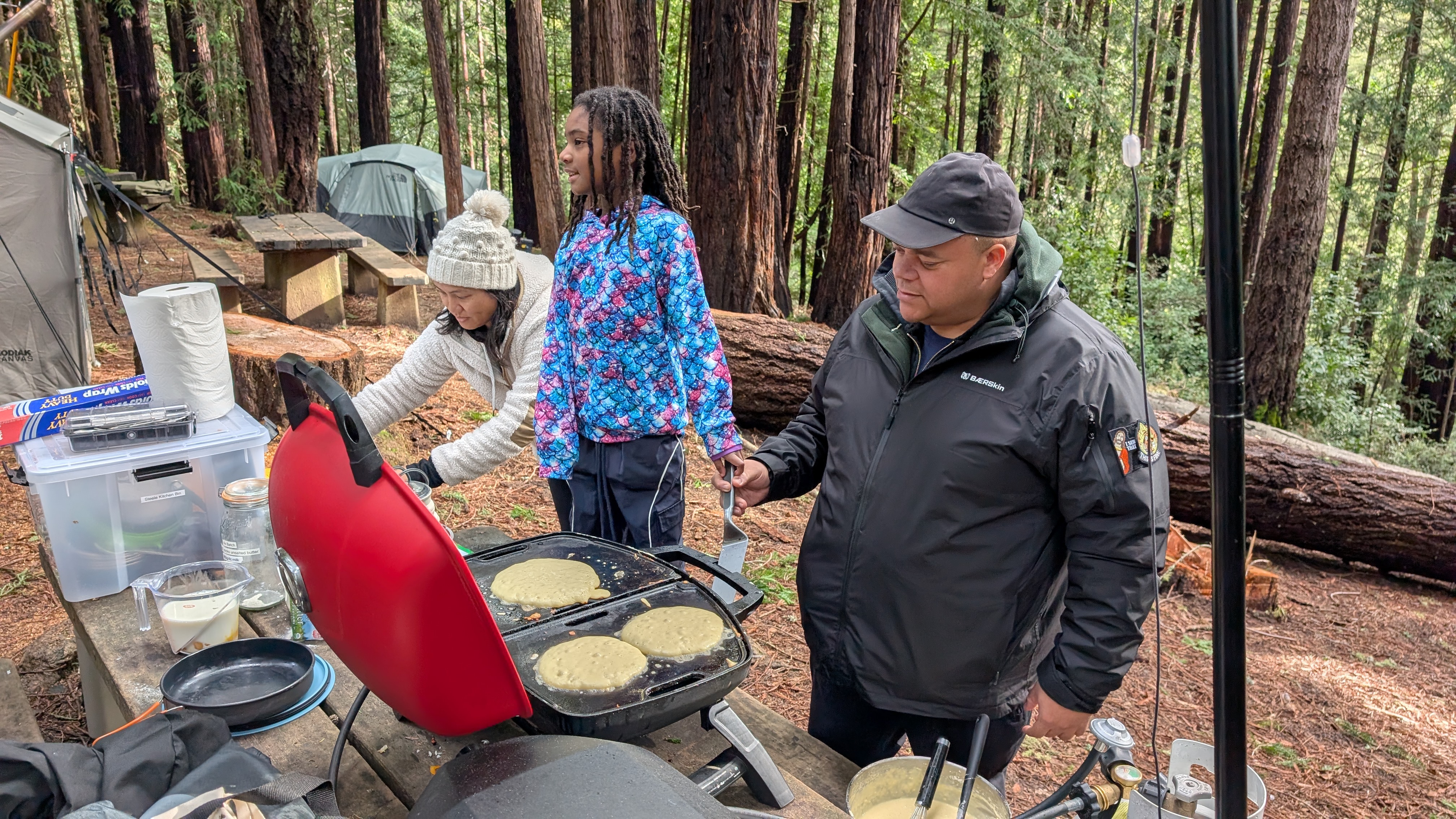 The Napoleon grill with dual burners cooking pancakes at a campsite