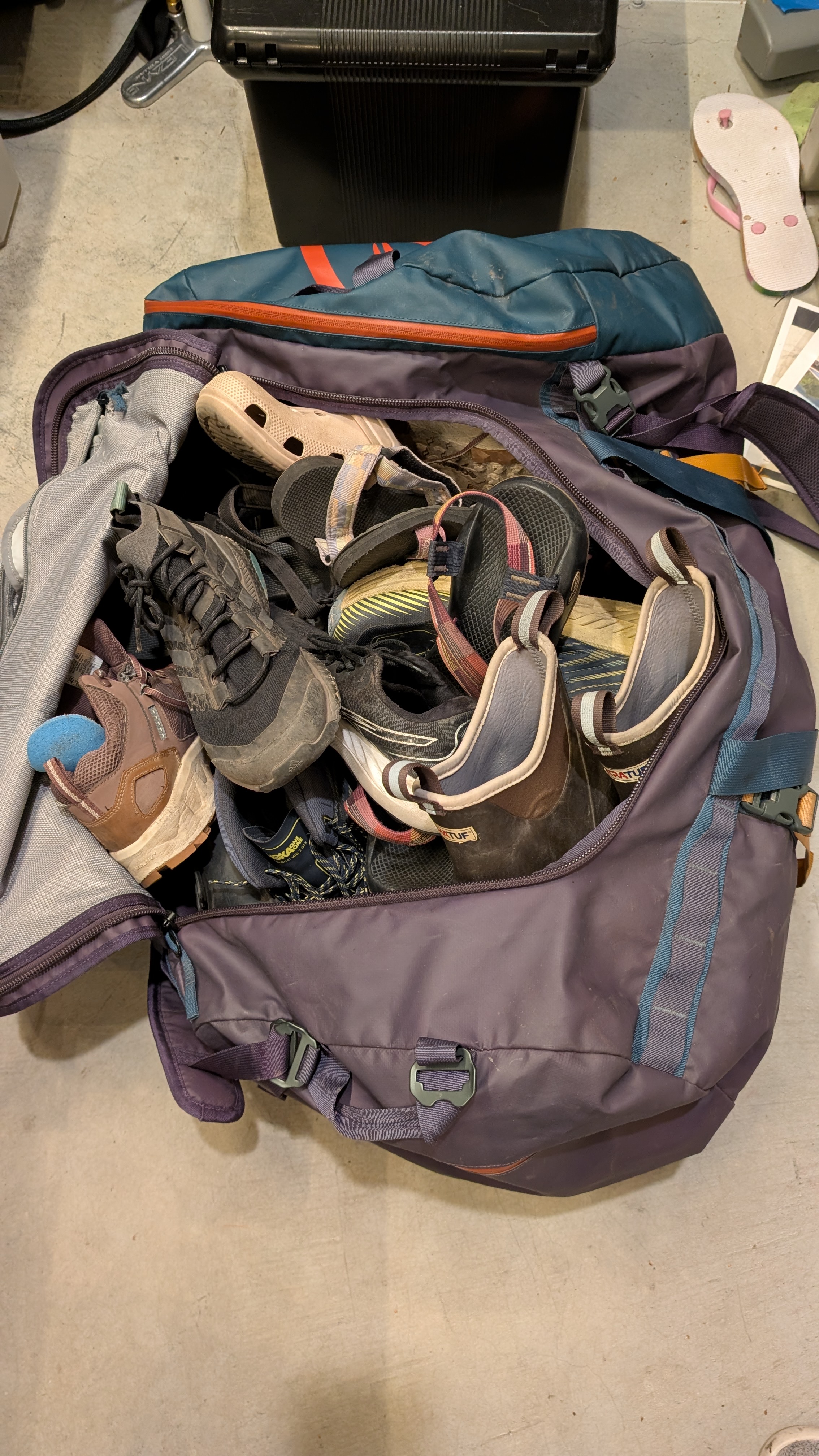 Overstuffed duffel bag full of family camping shoes