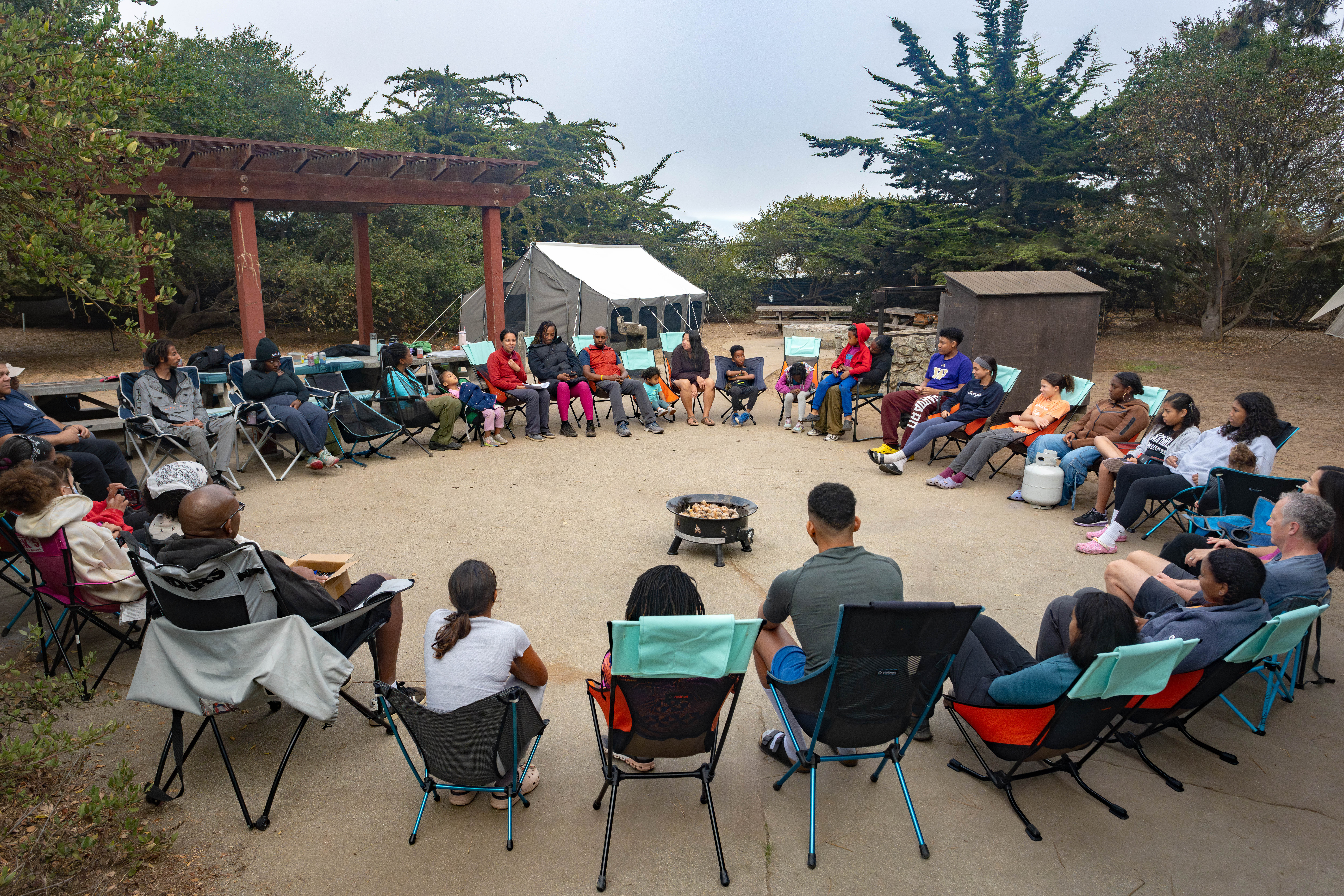 Family gathered around a campfire at their campsite