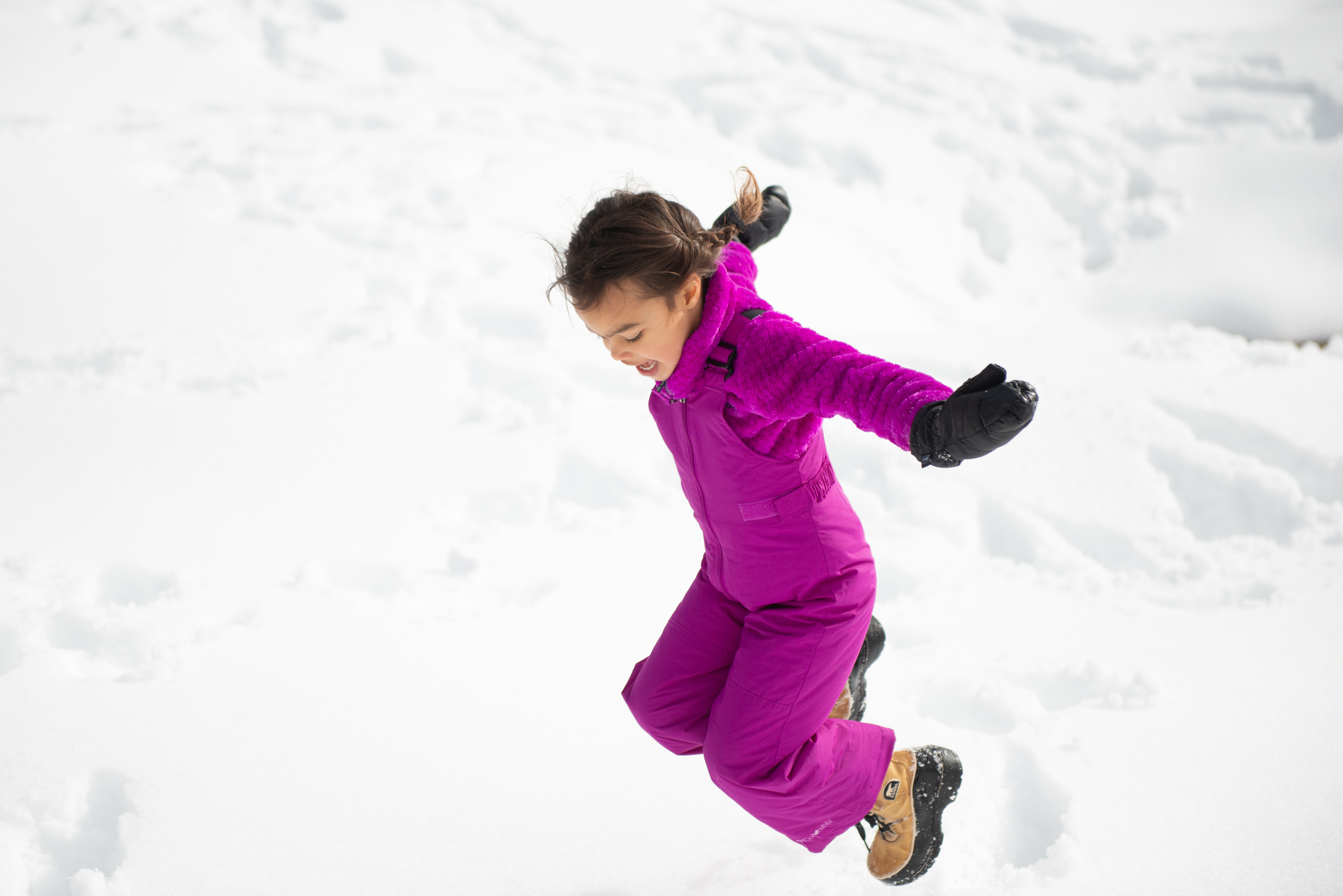 Children playing in the snow at a winter campsite