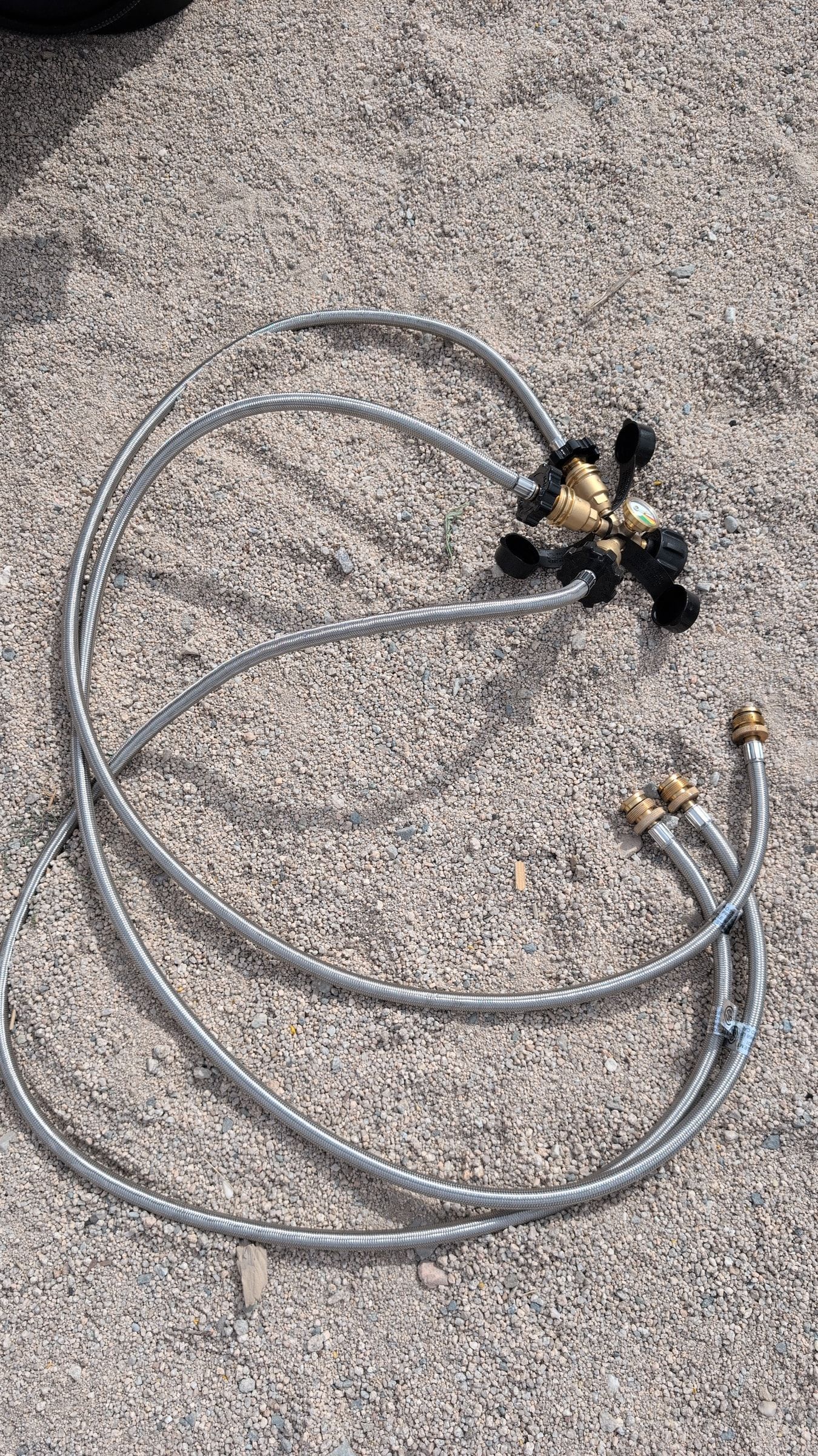 Photo of triple propane adapter and two braided hoses laid out