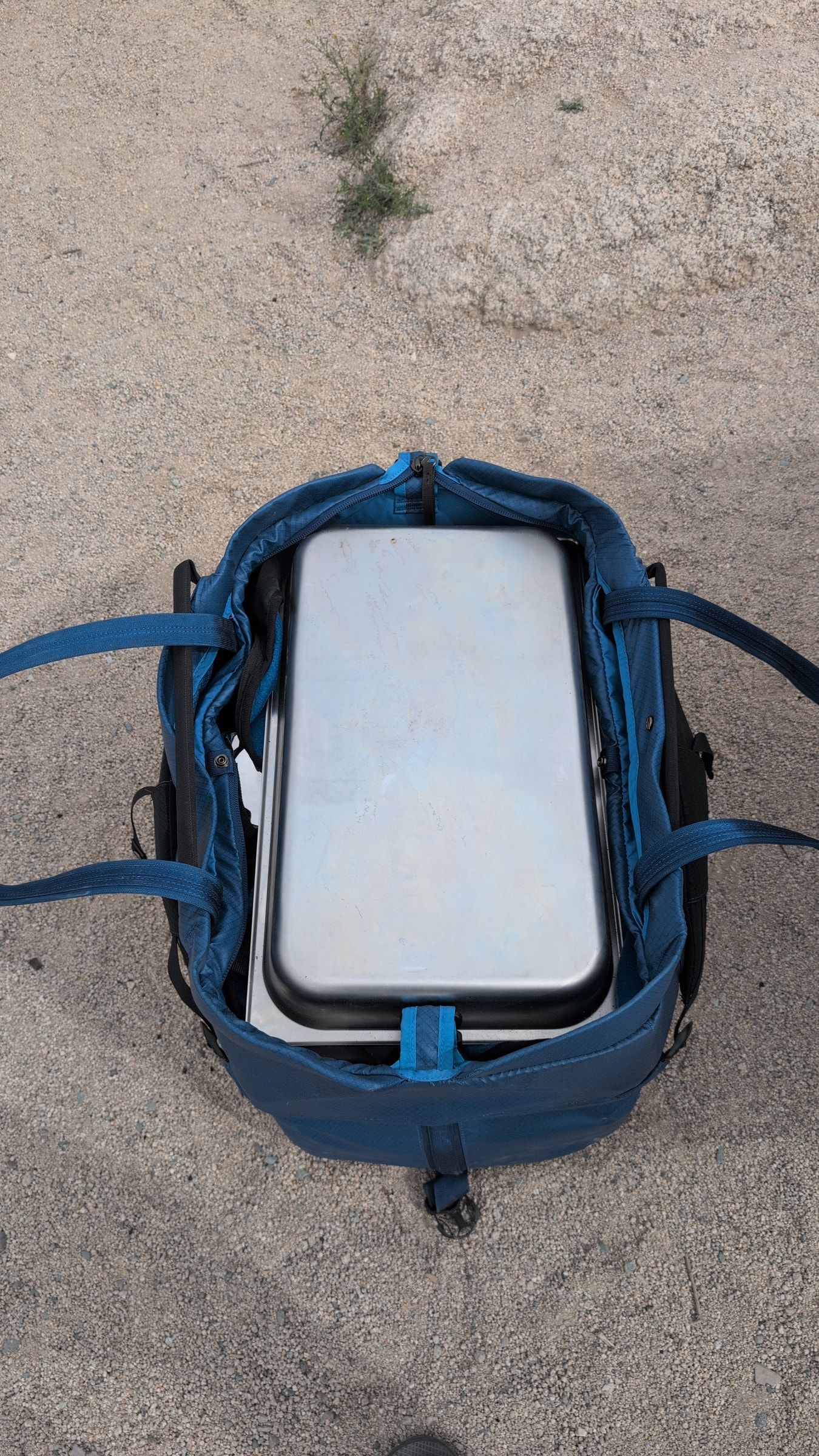 Photo of blue carrying bag opened to show a stainless chafing dish inside