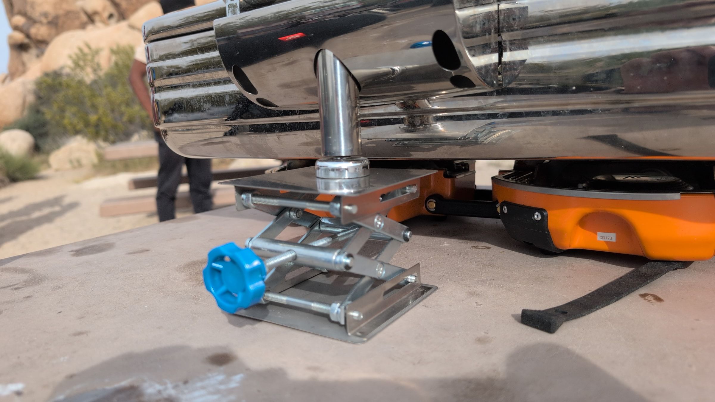 Close-up of metal riser with blue knob supporting the back of the chafing dish