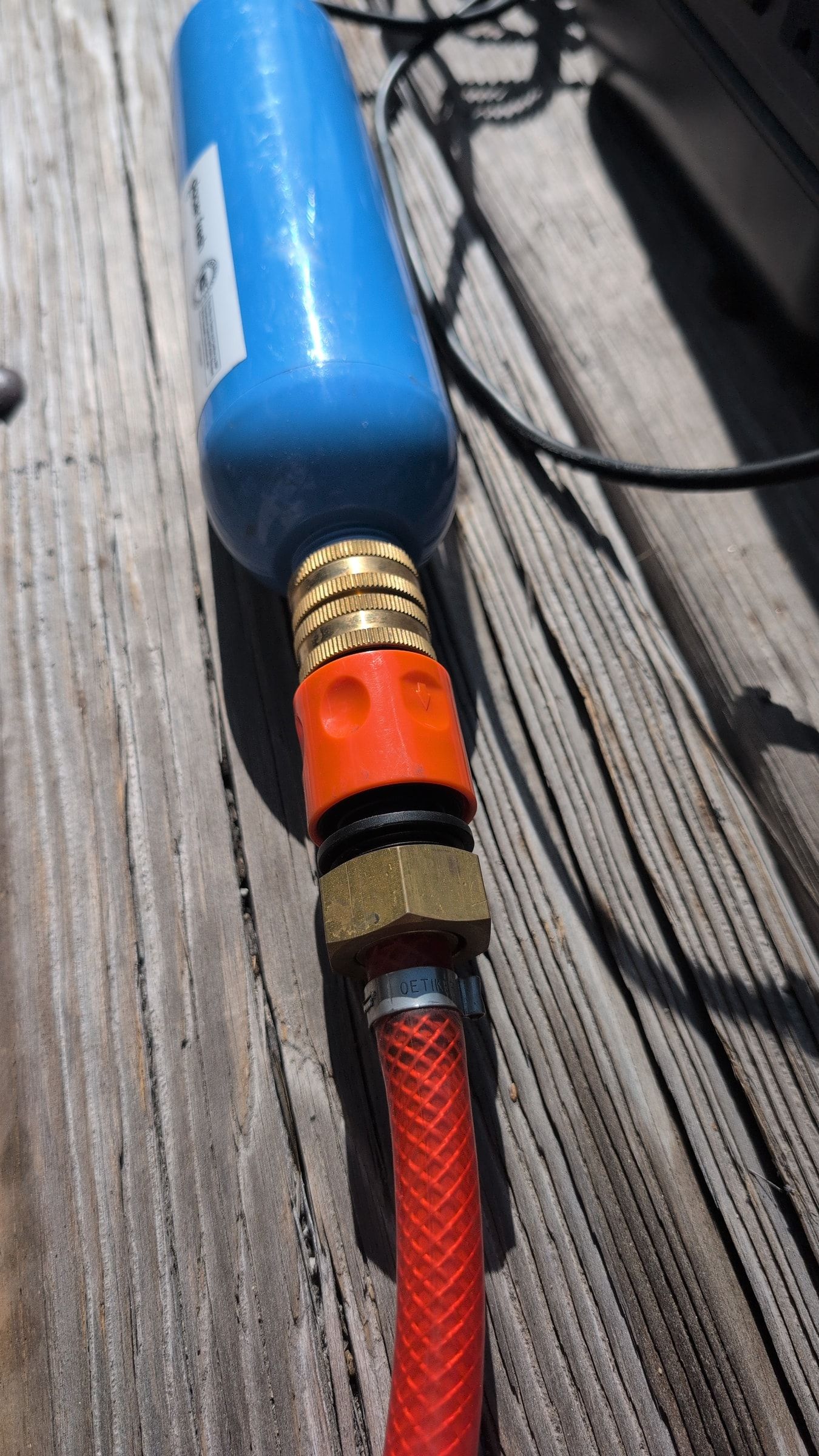 Close-up of red inlet hose connected to Glacier Fresh inline filter