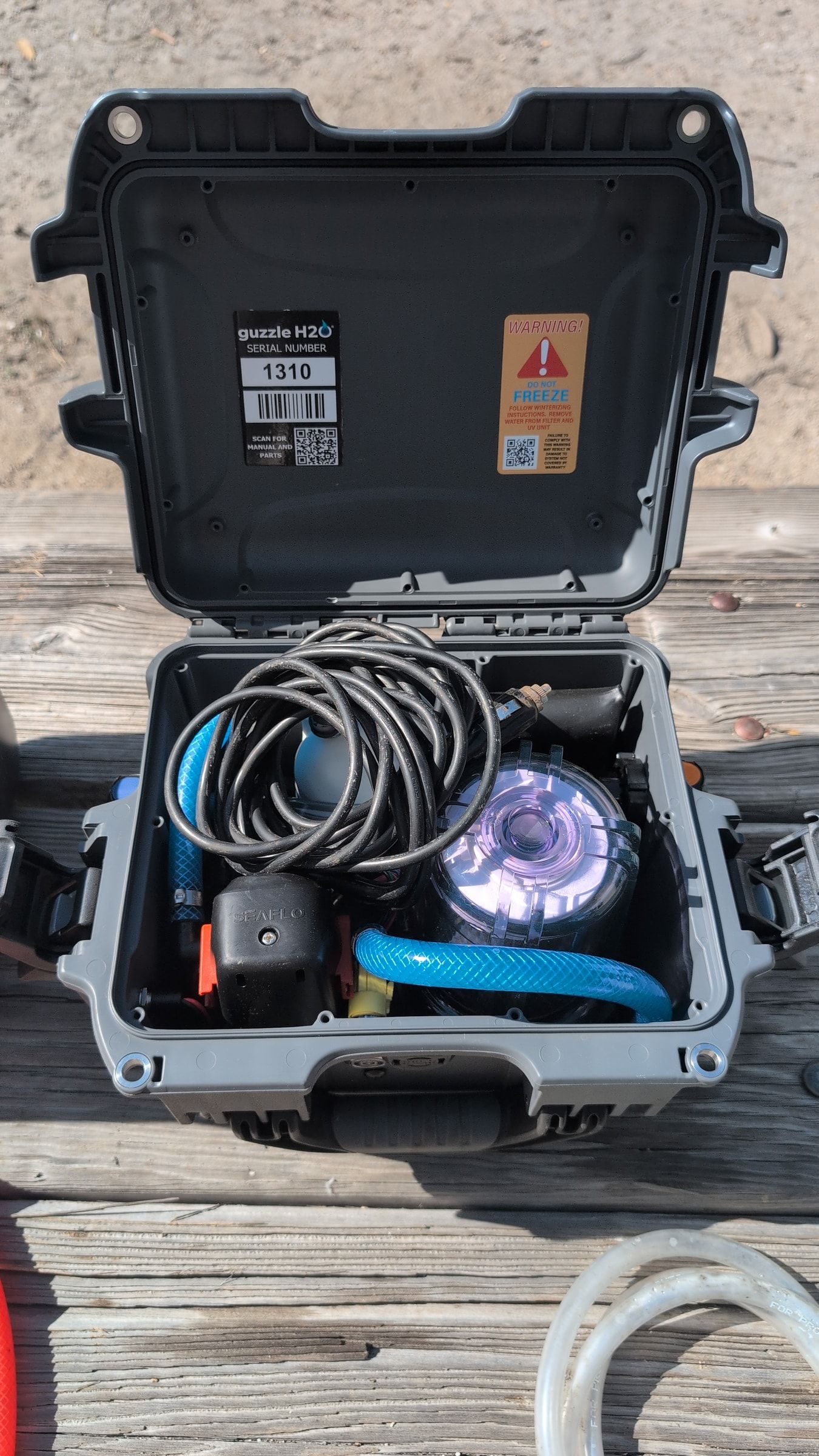 Photo of Guzzle H2O compartment open showing power cord and internal pump