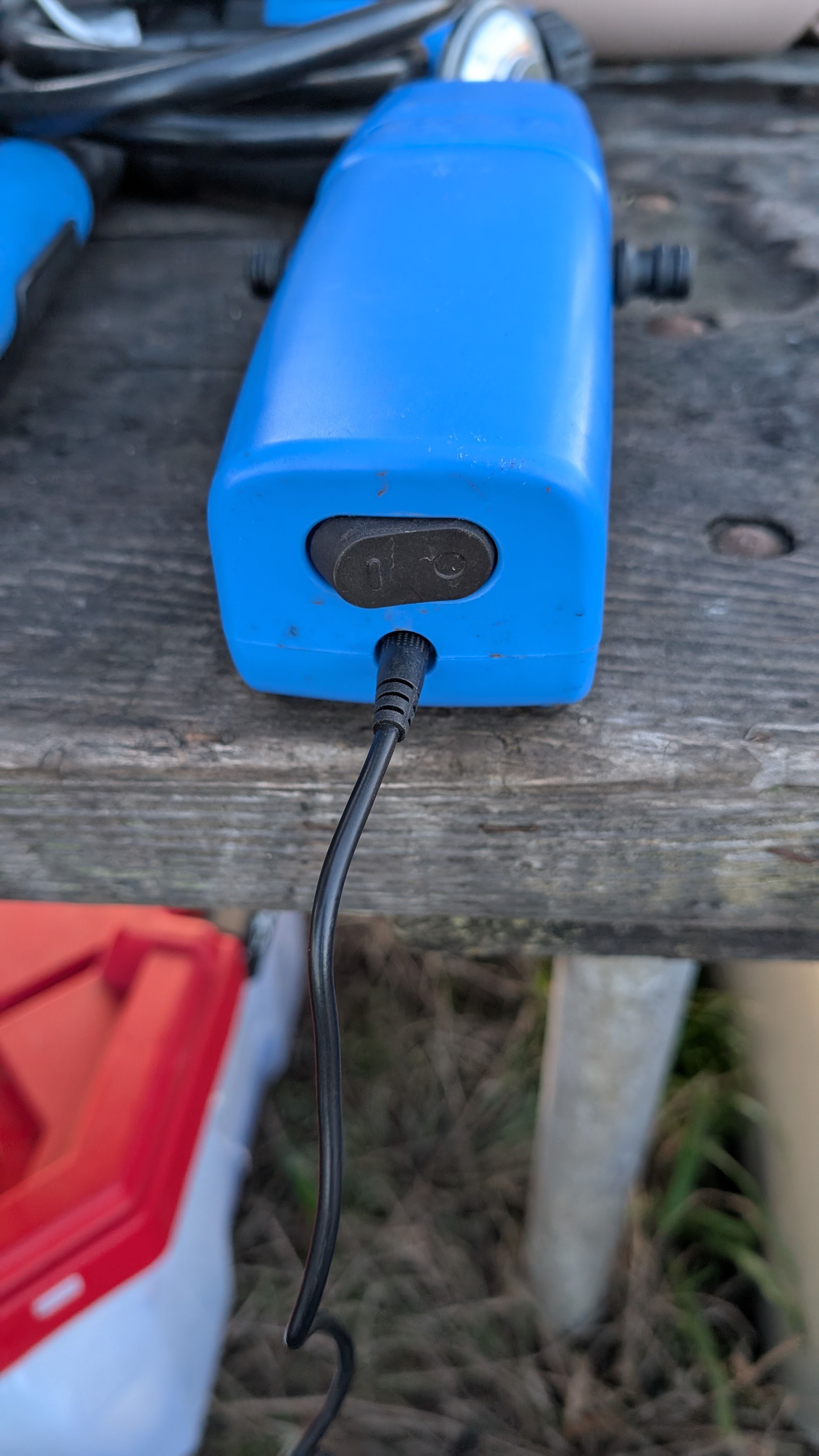 Photo of blue Joolca pump with power cord connected and on-off switch visible