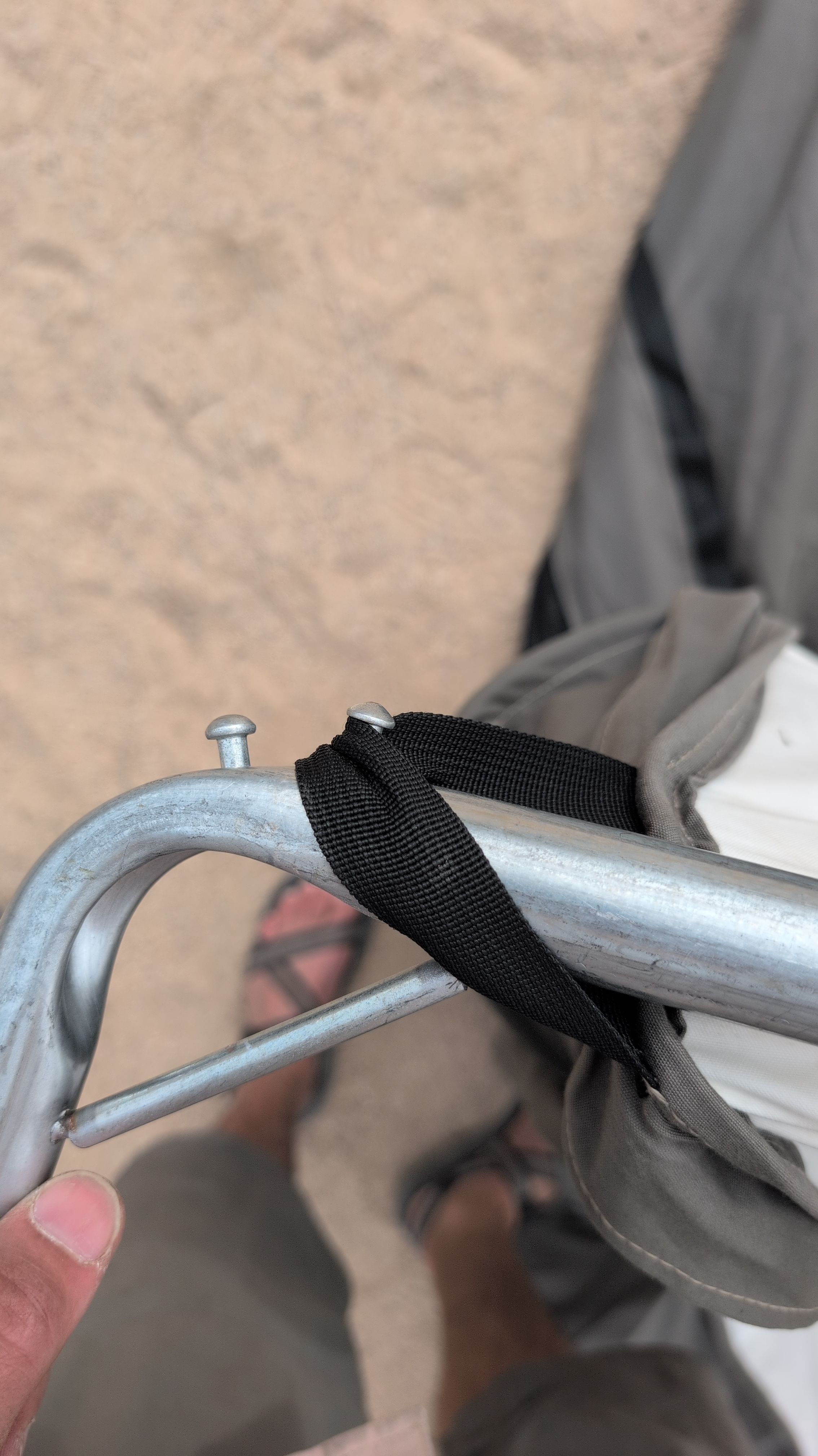 Photo close-up of black webbing strap positioned between the two pins on an upright pole