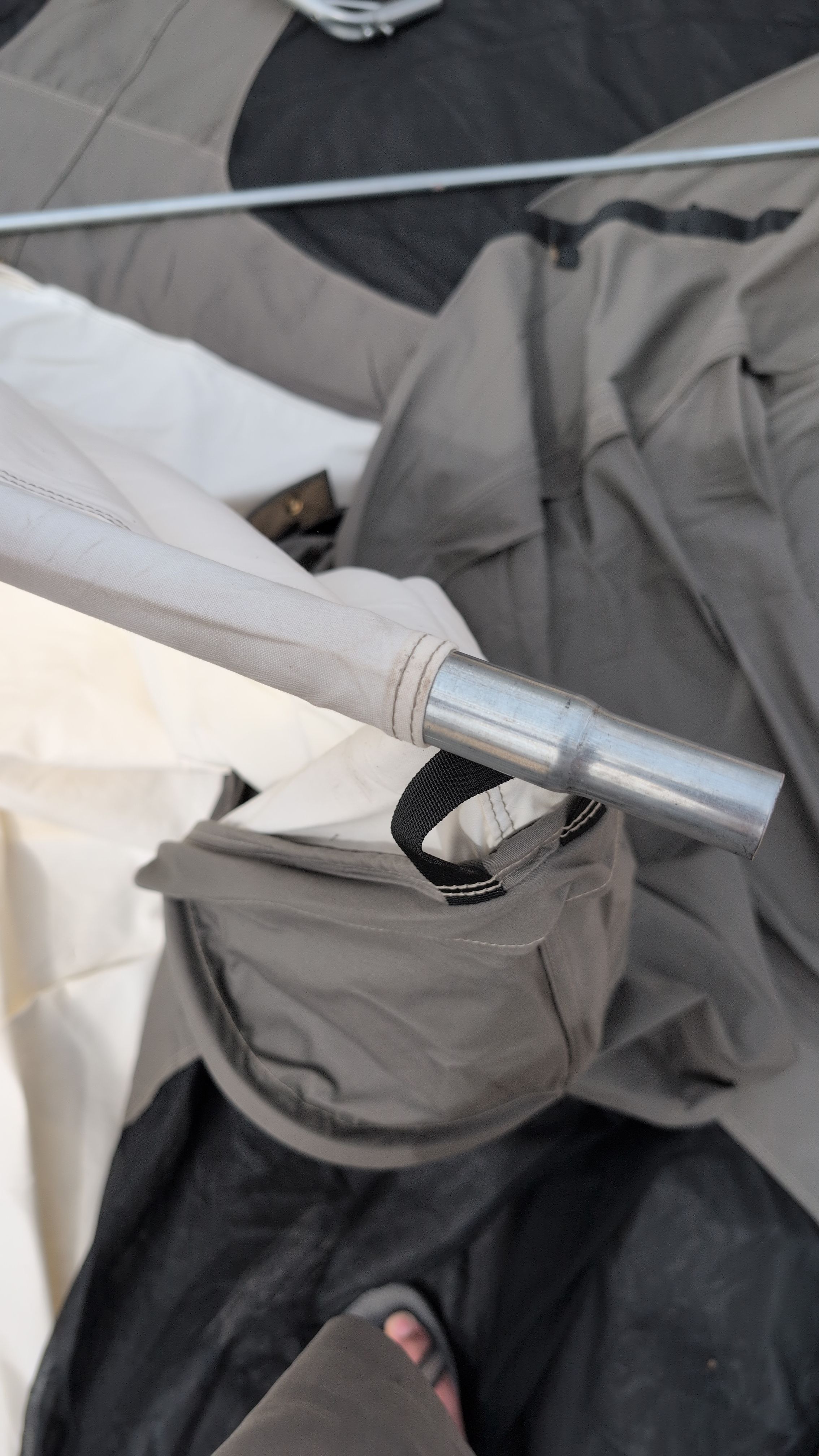 Photo of ridge pole being threaded carefully through the center roof sleeve