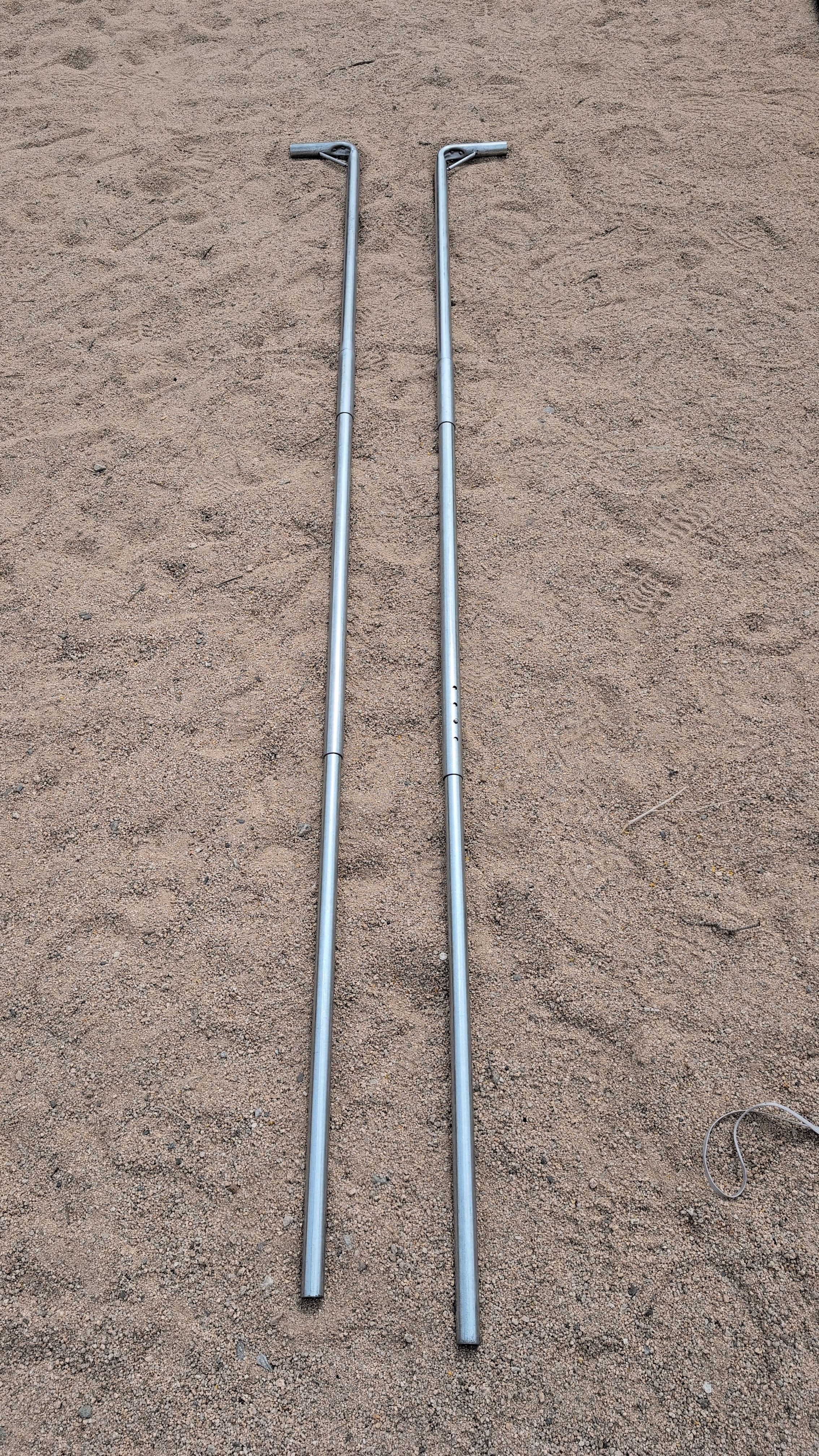 Photo of two upright end poles laid out next to the door ends of the tent