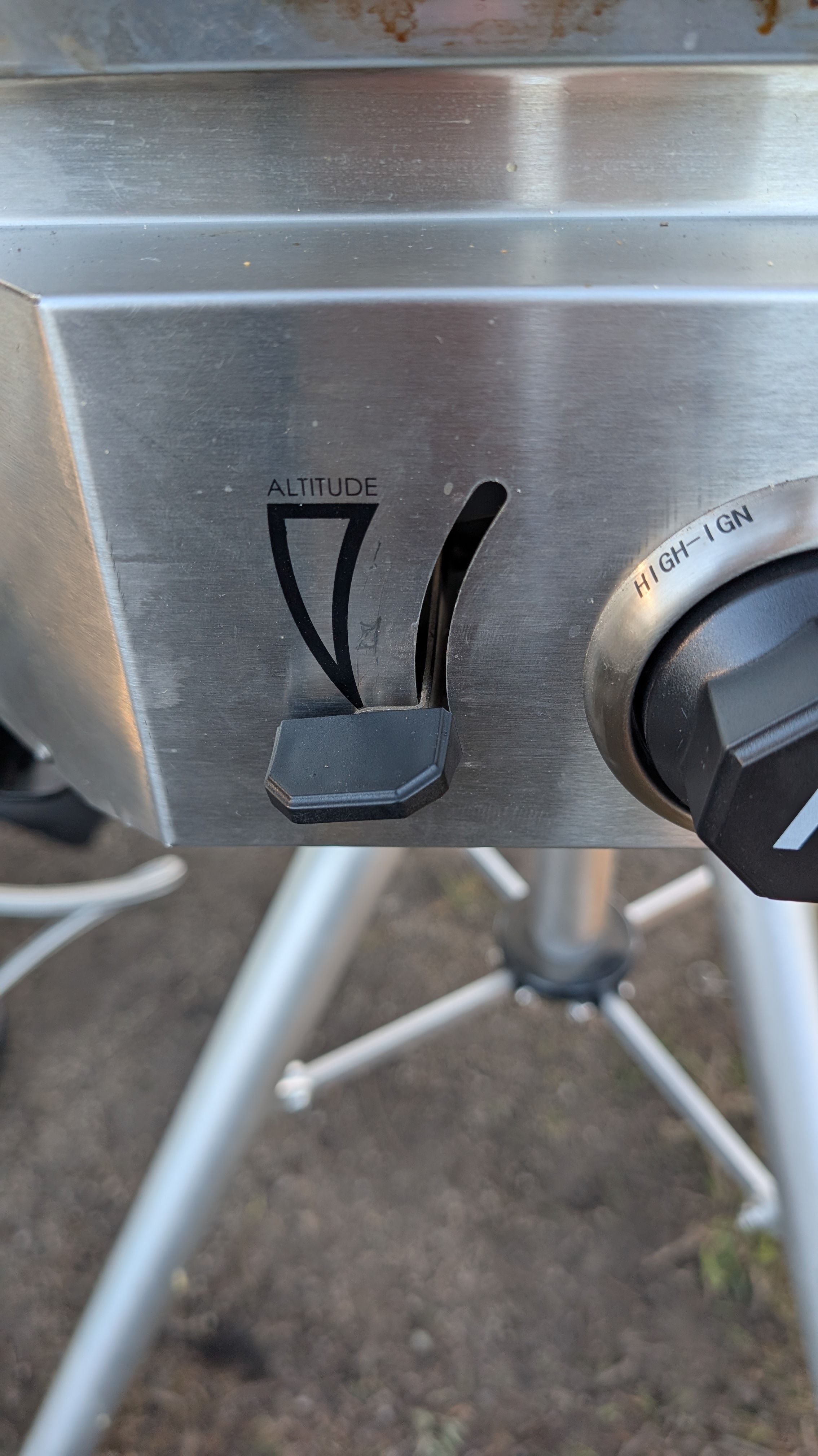 Close-up of altitude adjustment lever and ignition knob showing HIGH-IGN label