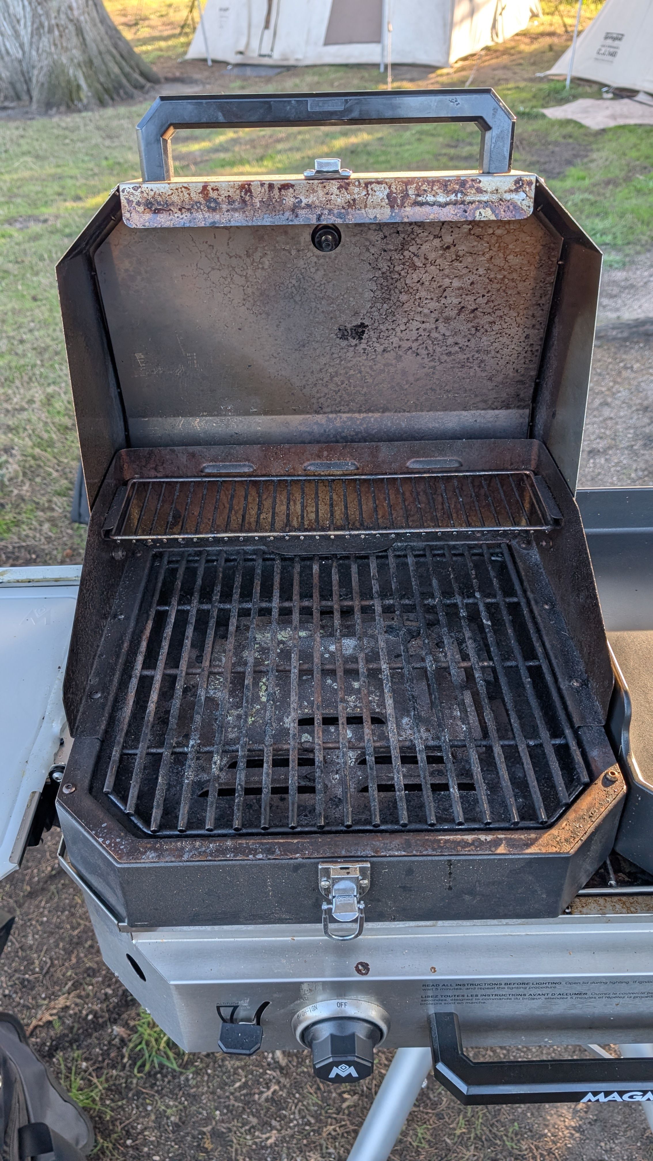 Photo of covered grill attachment open showing stainless steel cooking grates