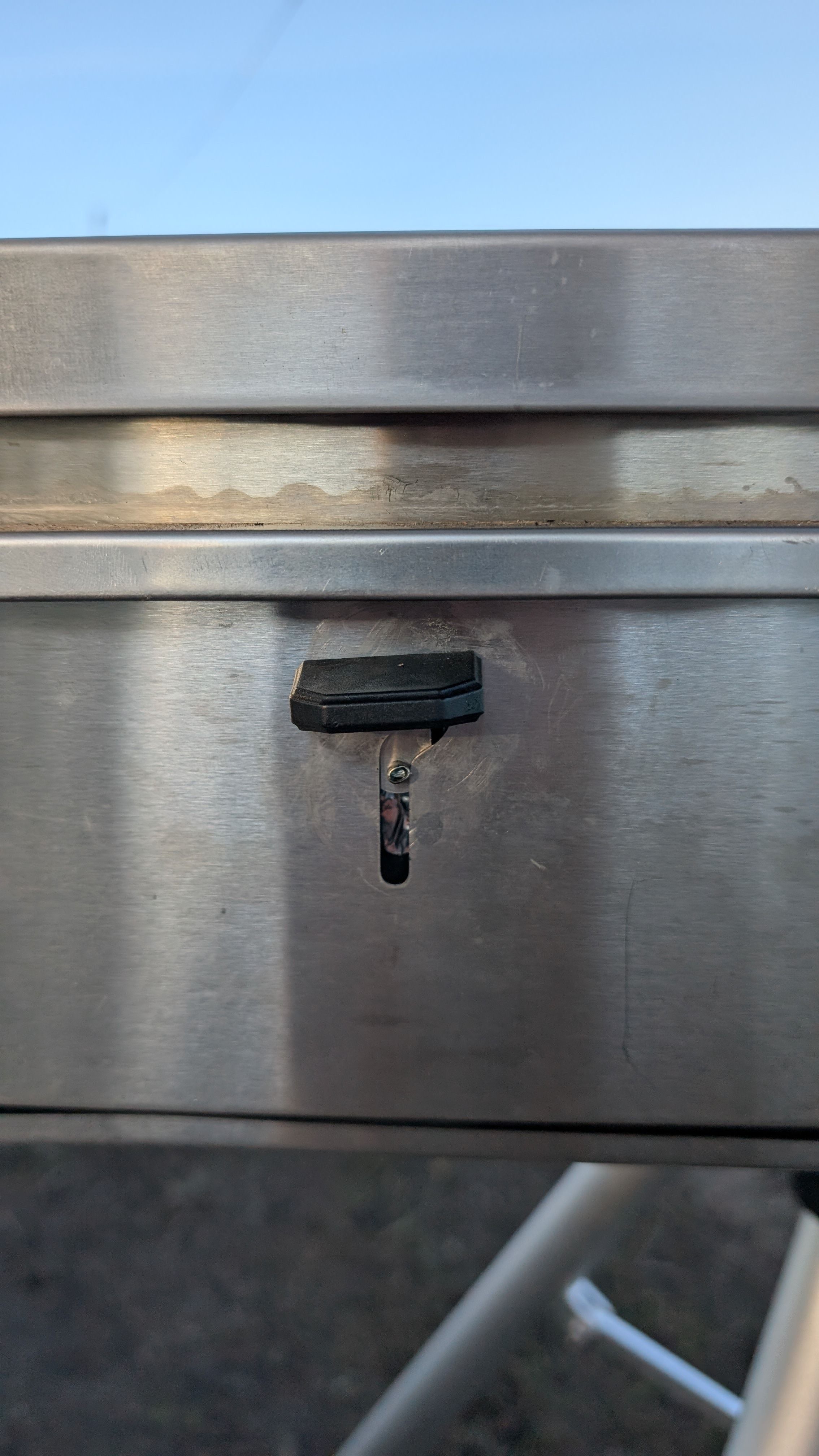 Photo of grease trap latch pushed up to the locked position
