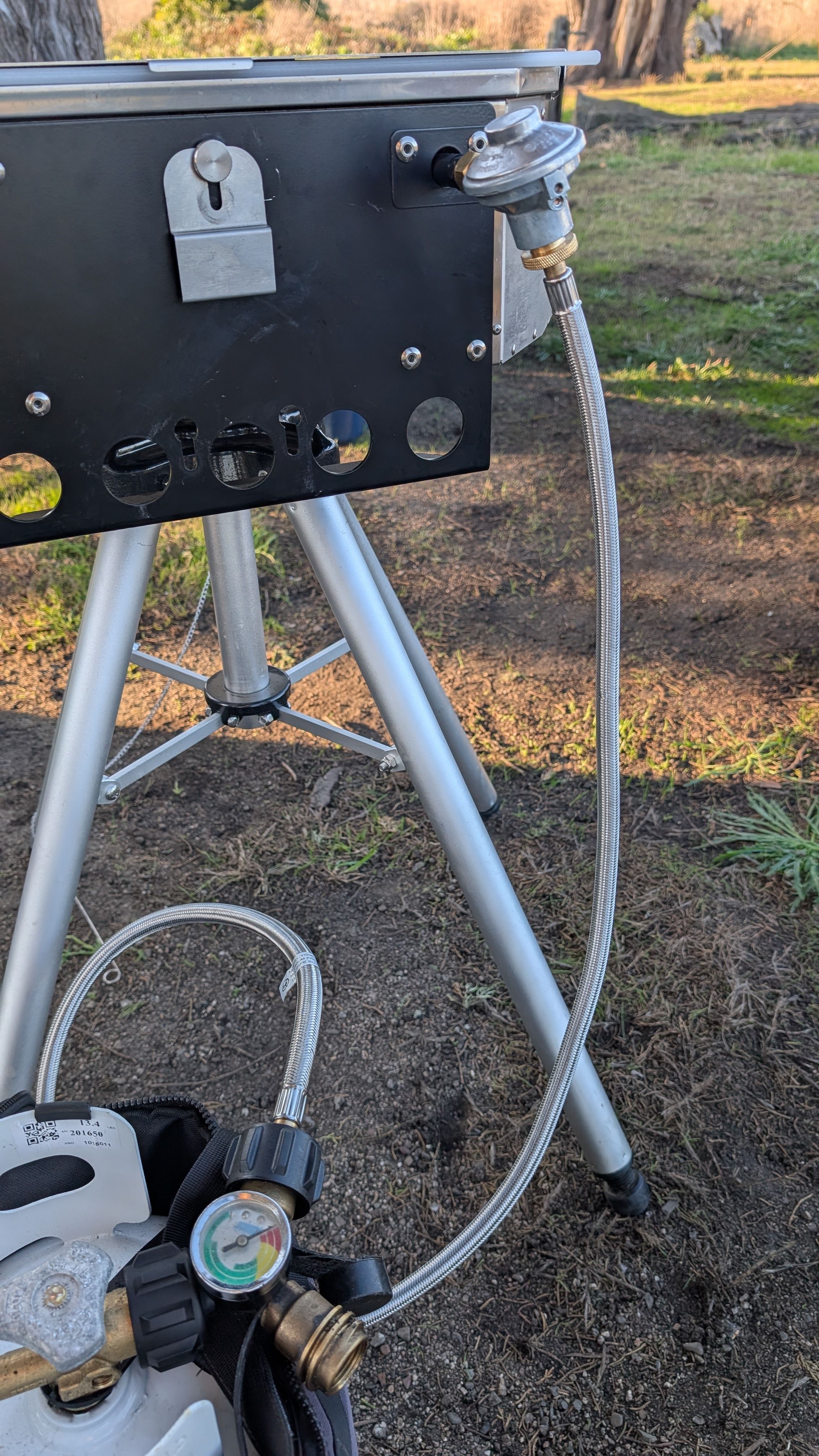 Photo of single burner Crossover mounted on tripod with propane splitter visible