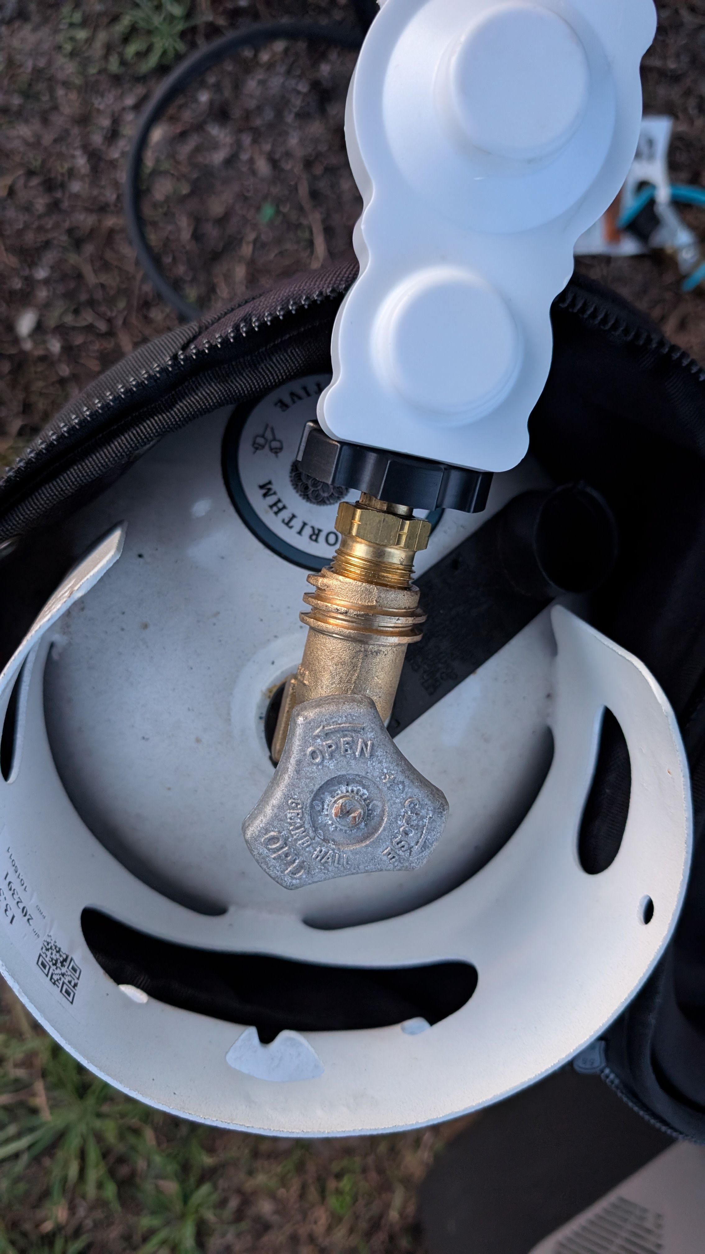 Photo of propane regulator being attached to standard propane tank