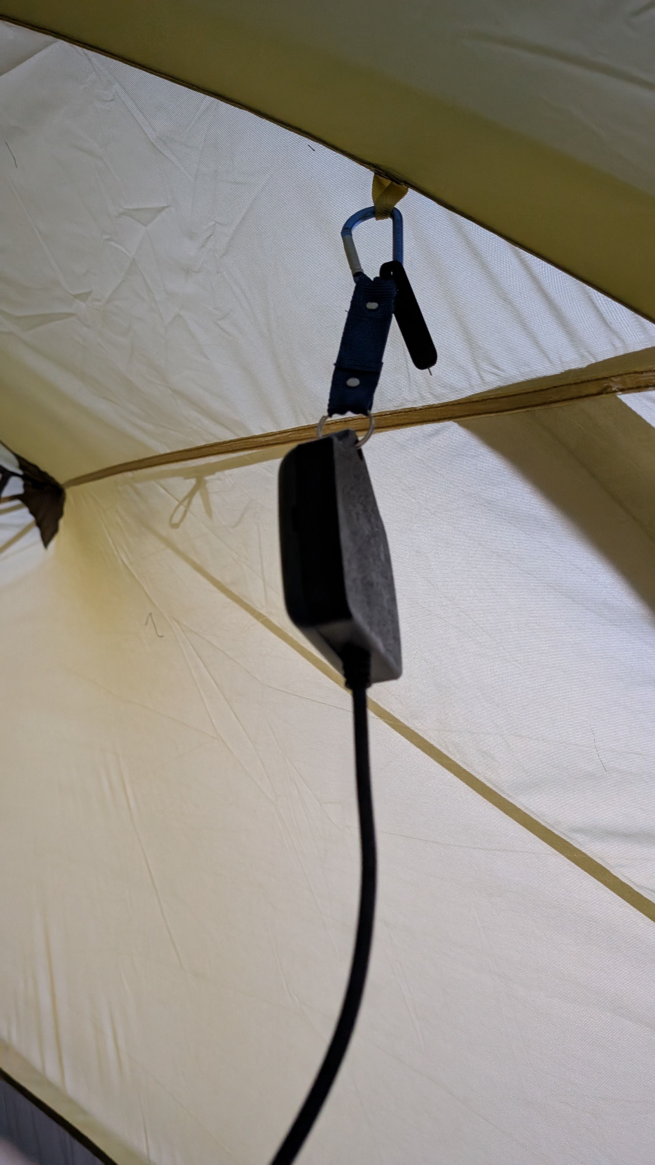 Photo of thermostat hanging inside tent in open air area