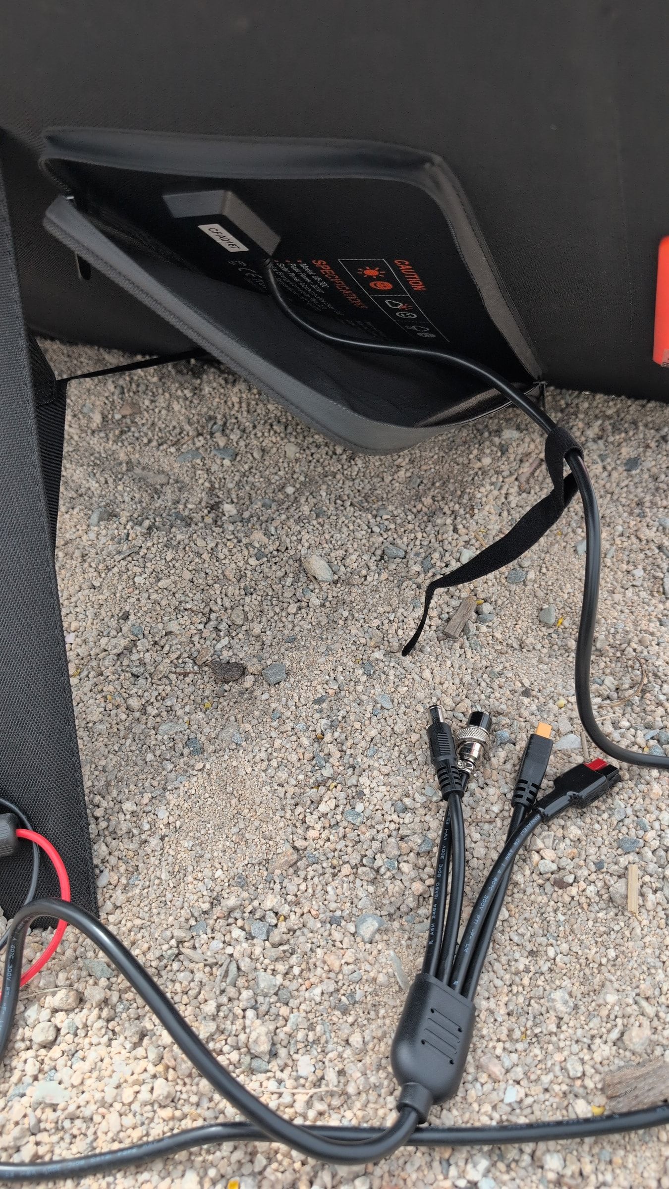 Photo of folded Grecell solar panel with red handle and storage pocket visible
