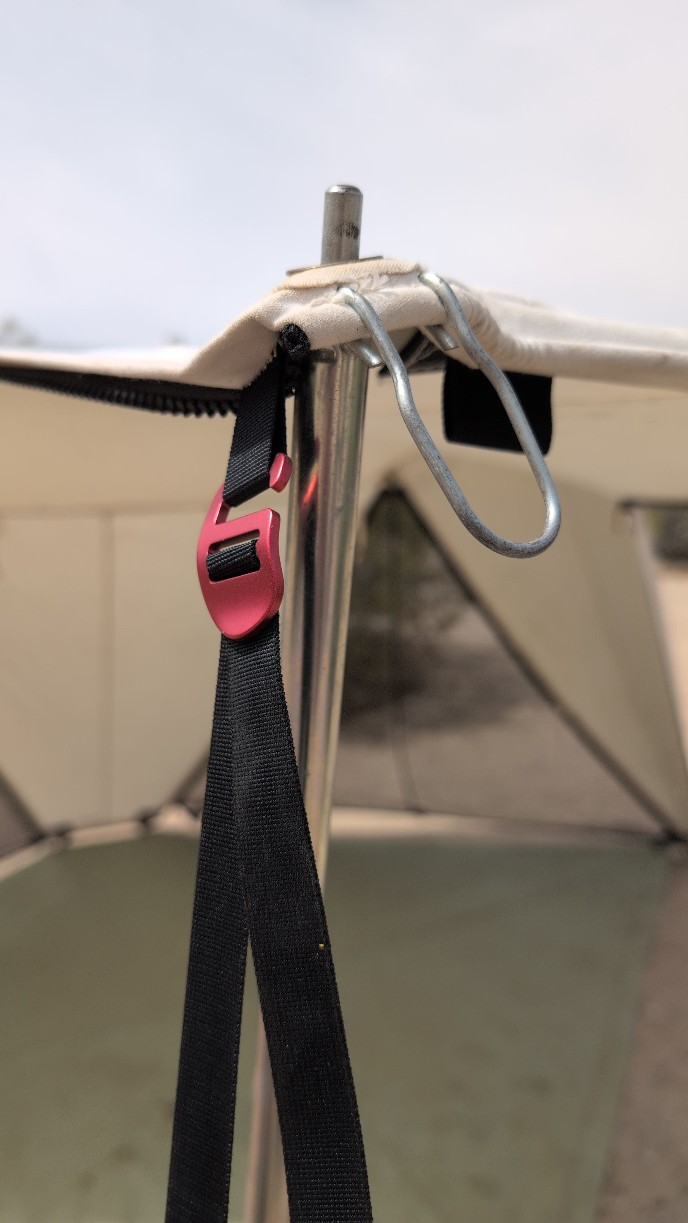 Close-up of red hook connector on the edge where the awning support pole attaches