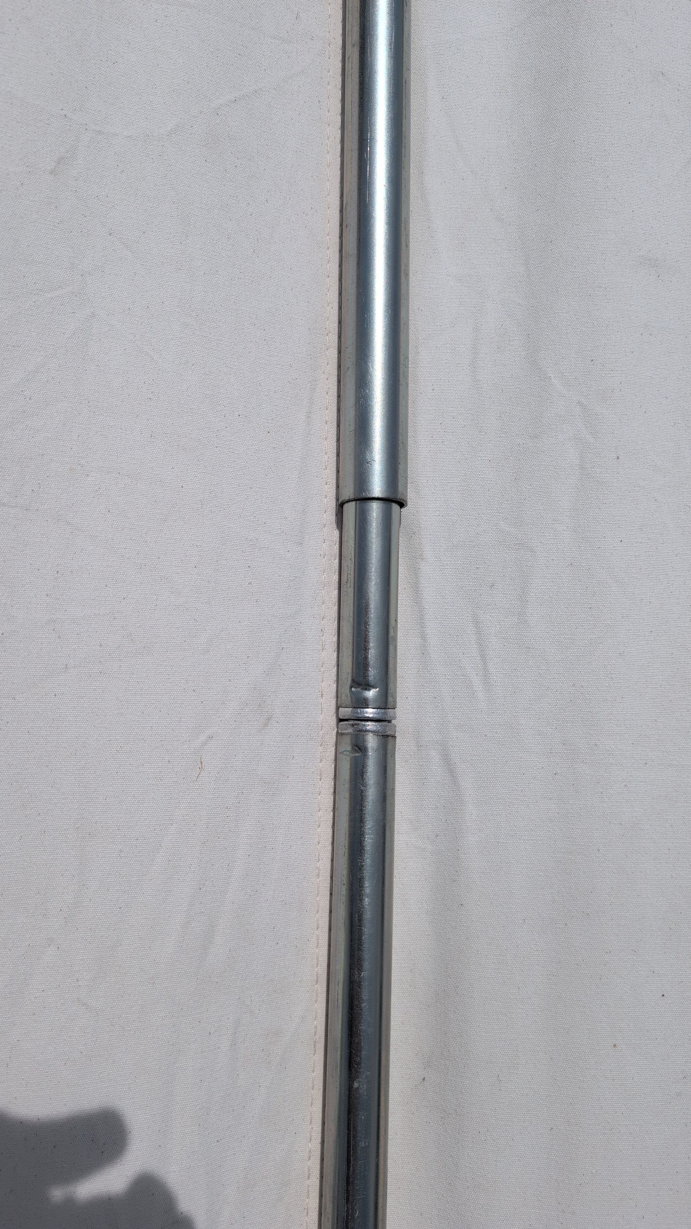 Photo of crossbar poles fully tensioned, slip cover ready to slide over center joint