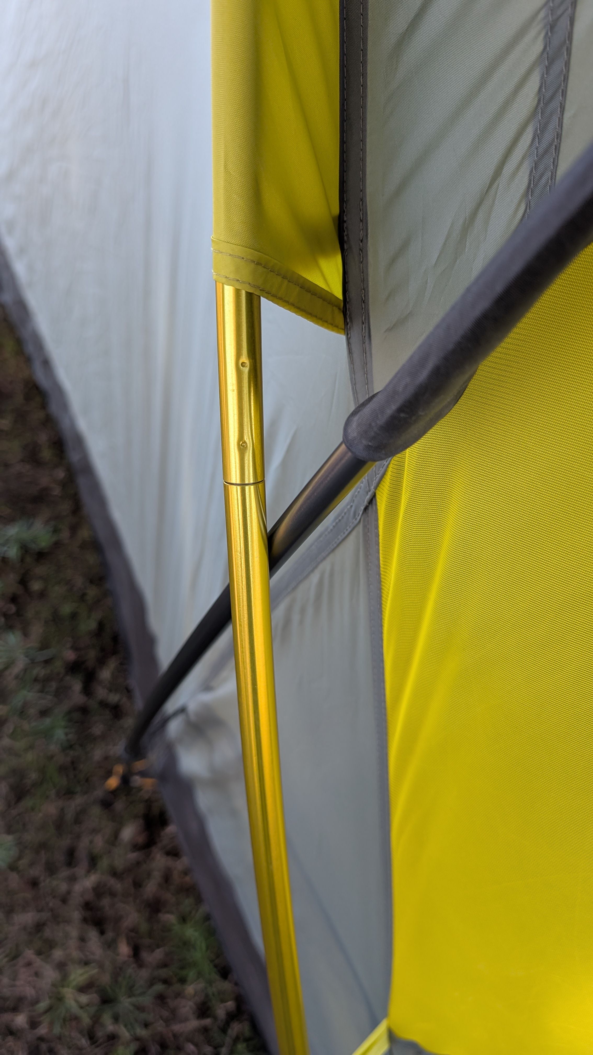 Photo showing gray pole going under yellow pole