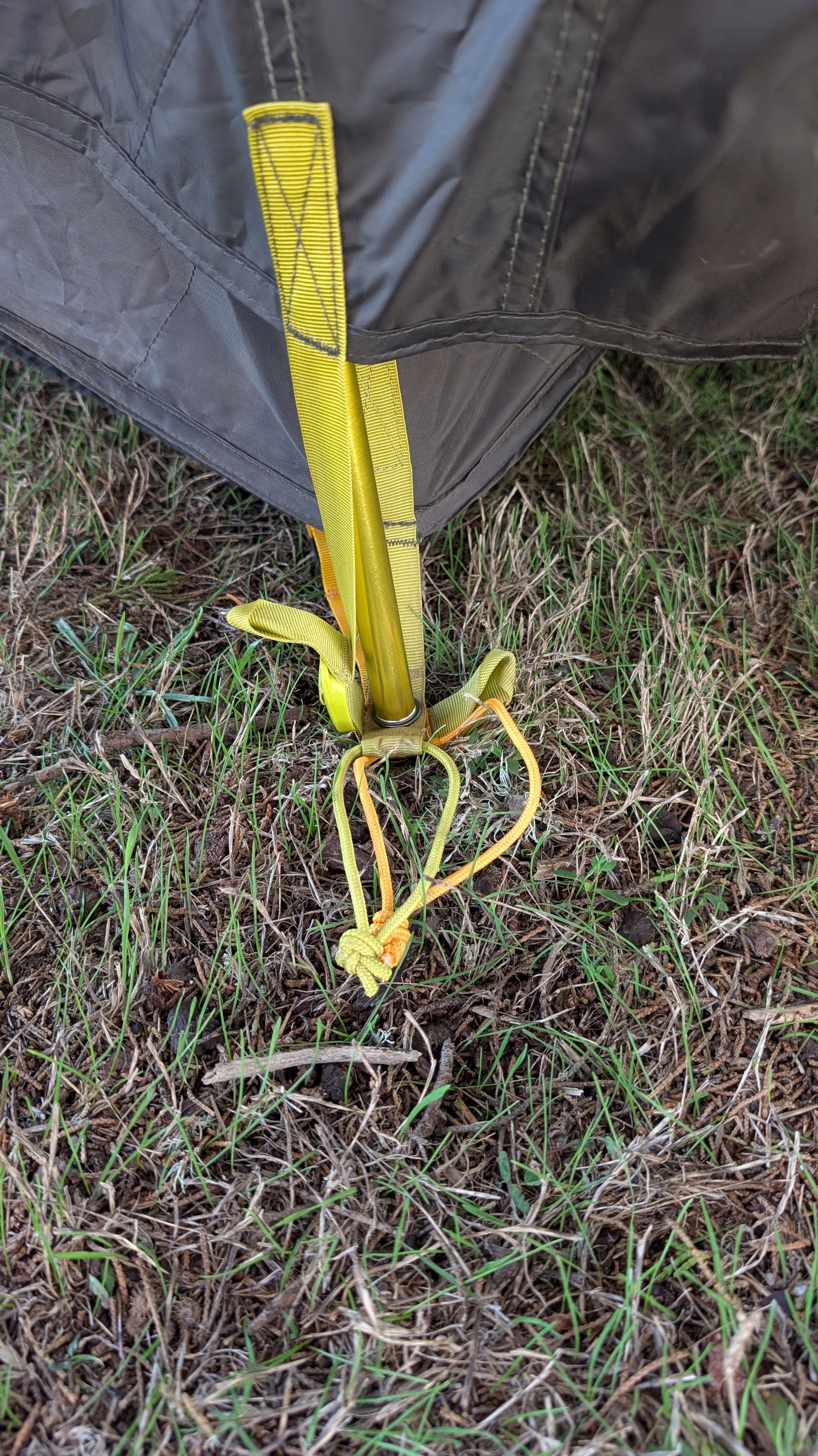 Photo showing vestibule grommet under tent corner grommet on stake