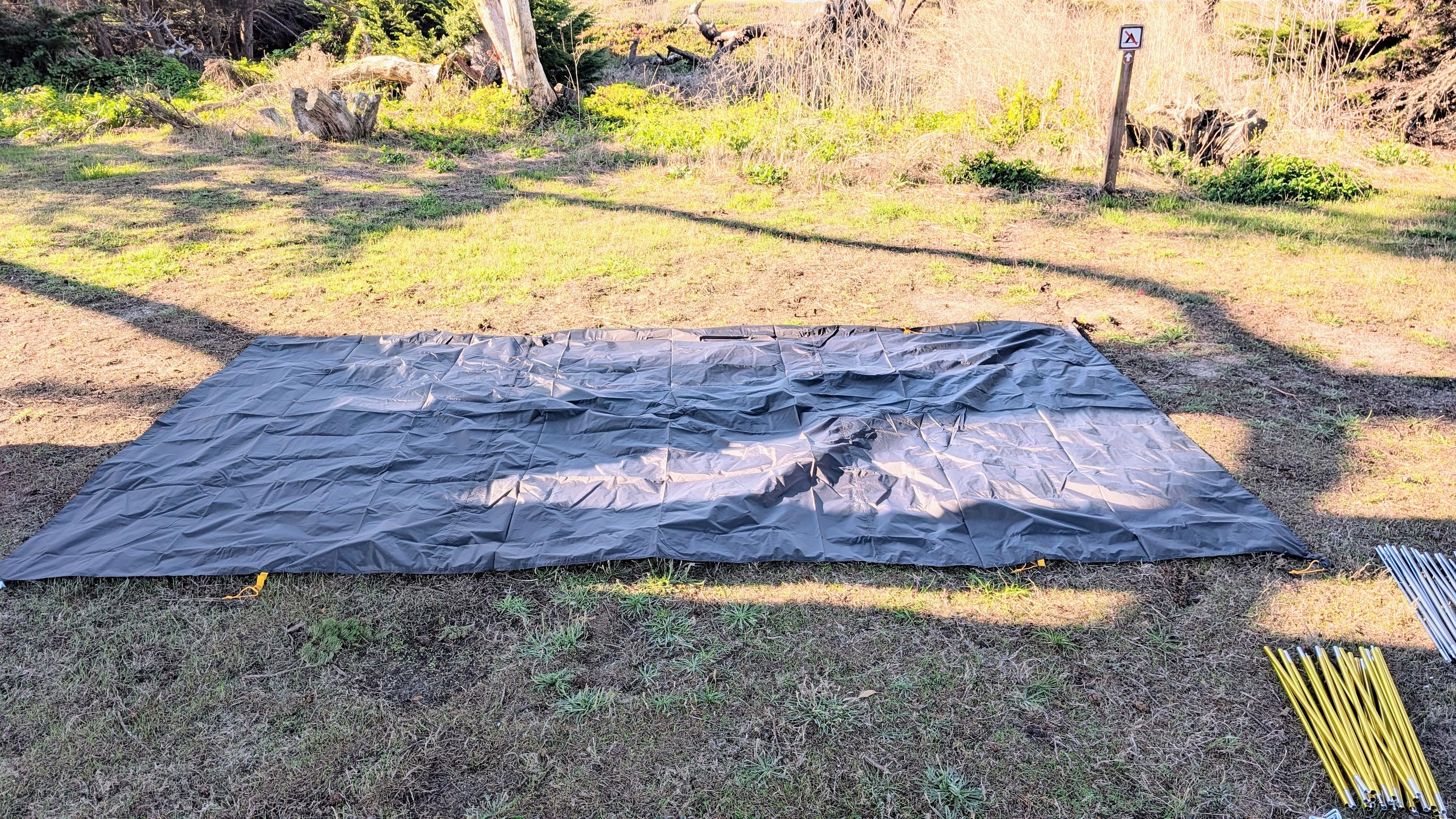 Photo of ground sheet laid flat on cleared campsite